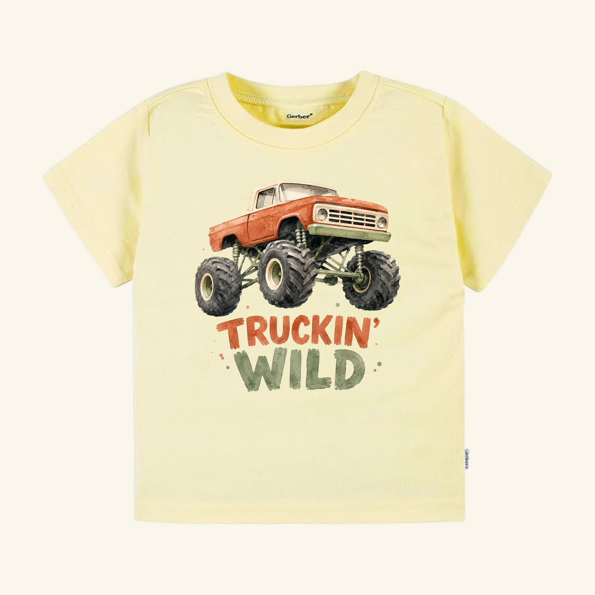 Pale yellow Monster Truck Toddler Shirt – Truckin’ Wild Short-Sleeve Tee featuring an orange monster truck illustration and the text TRUCKIN WILD.