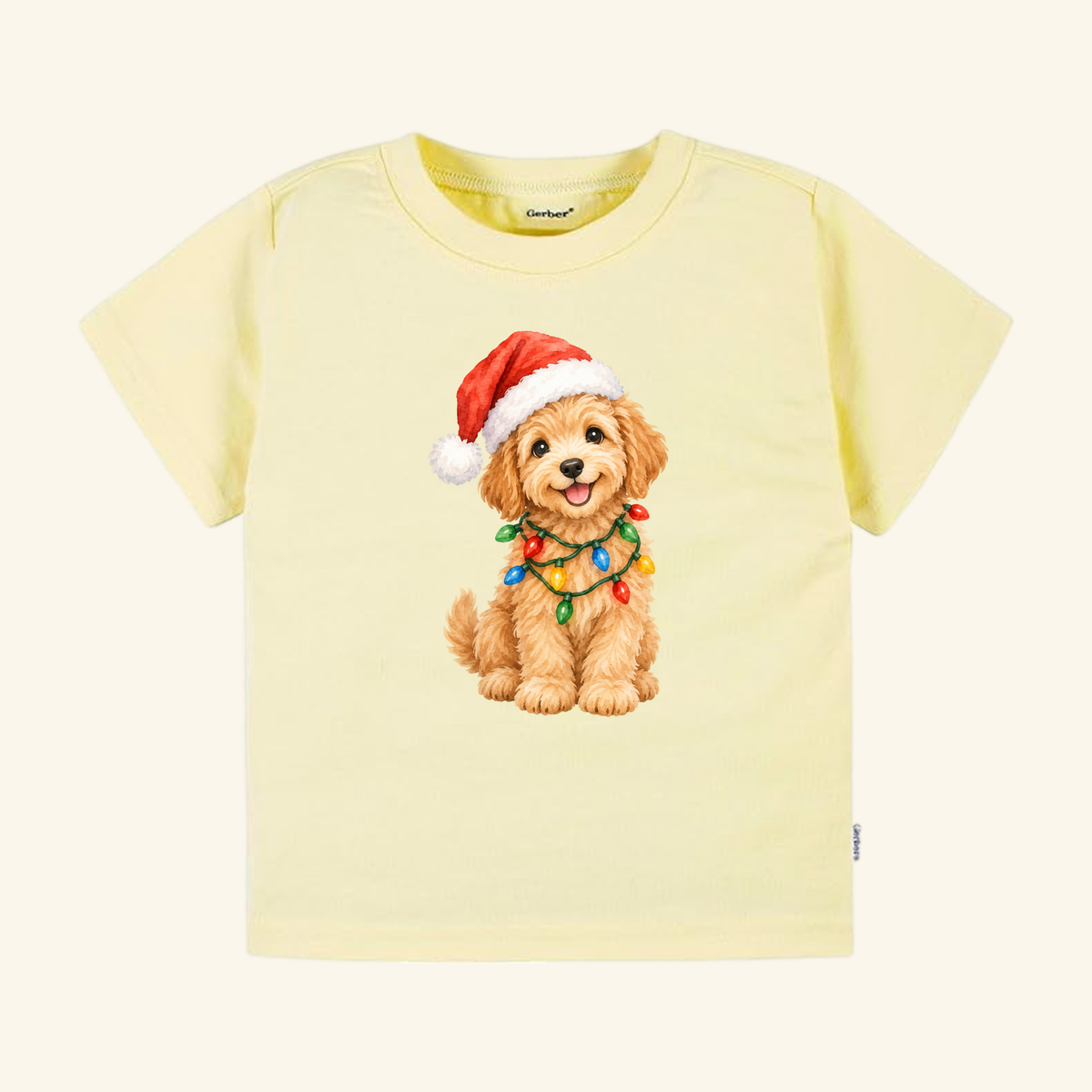 Light yellow short-sleeved Christmas Puppy Toddler Shirt – Cute Goldendoodle Holiday Tee featuring a Goldendoodle wearing a Santa hat and a string of colorful lights.