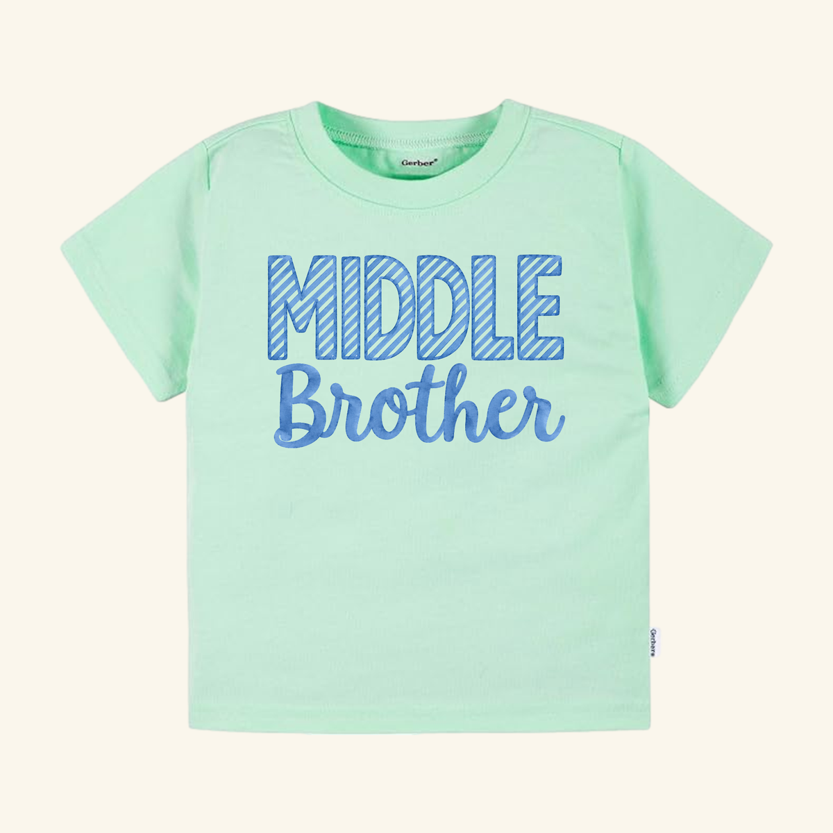 Light green short-sleeved Middle Brother Toddler Shirt with blue striped lettering.