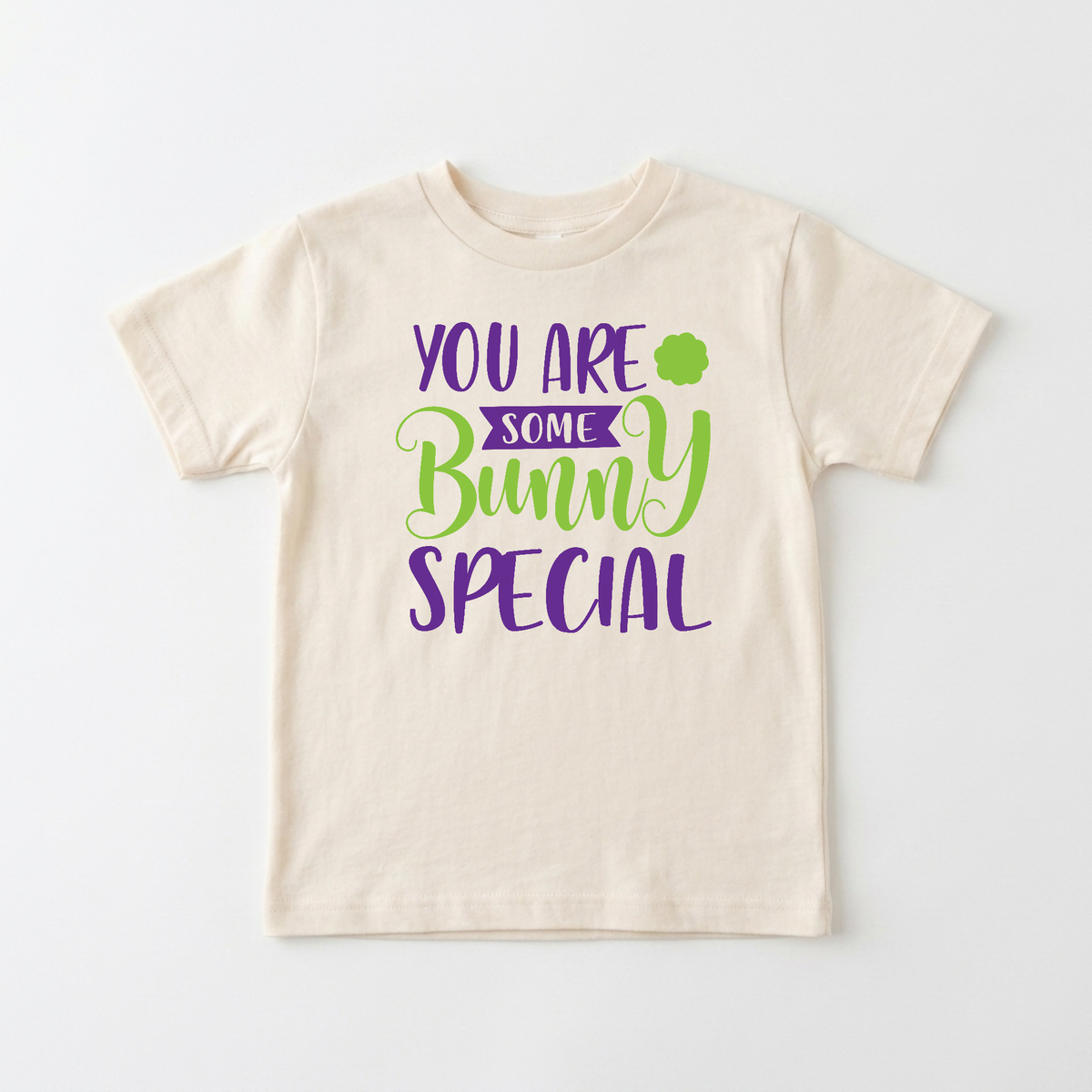 Toodleroos Easter Toddler Shirt – You Are Some Bunny Special Graphic Tee in cream, featuring purple and green text and a small clover icon.