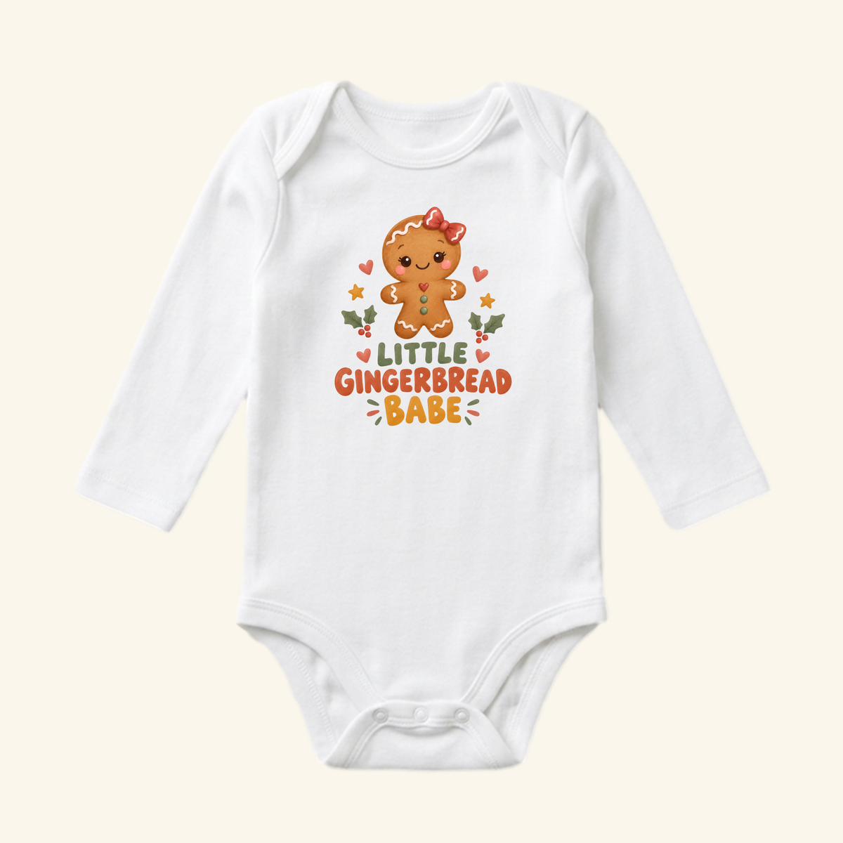 Little Gingerbread Babe Baby Onesie featuring a white long-sleeve design with a gingerbread cookie graphic, a red bow, and the text LITTLE GINGERBREAD BABE.
