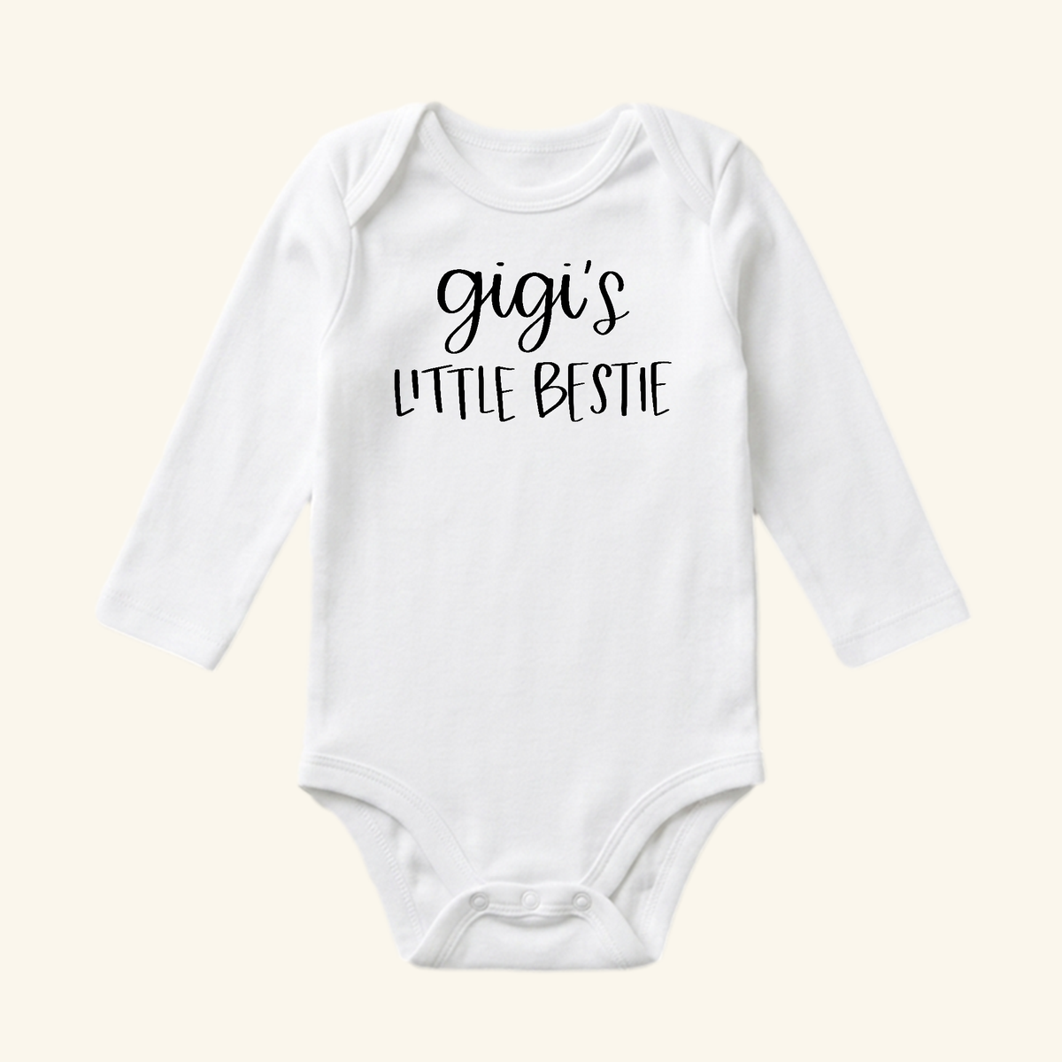 White long-sleeve Gigi Baby Onesie – Gigi’s Little Bestie Bodysuit with the phrase printed in black on the chest.