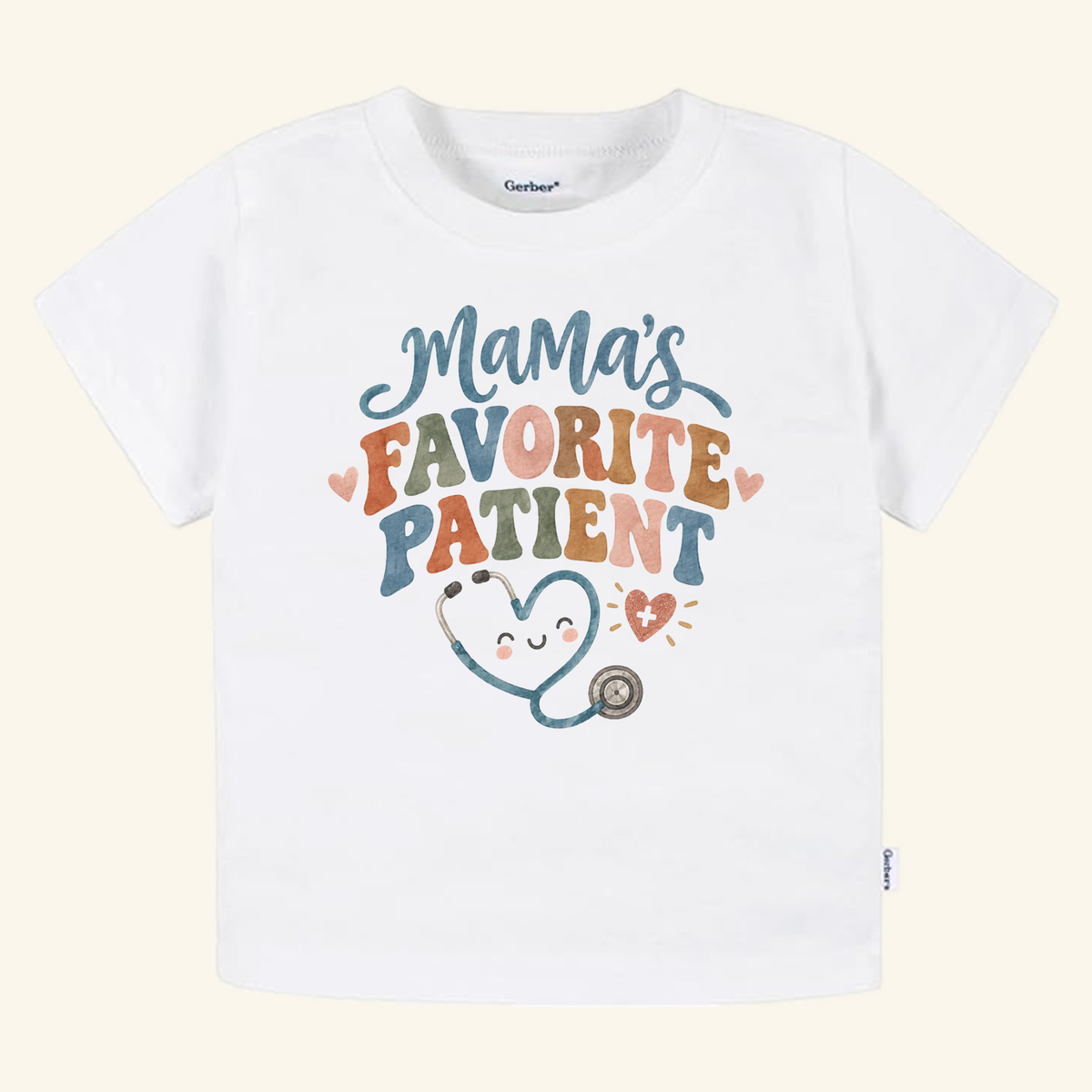 White Mama’s Favorite Patient Toddler Shirt featuring colorful text above a smiling heart-shaped stethoscope.