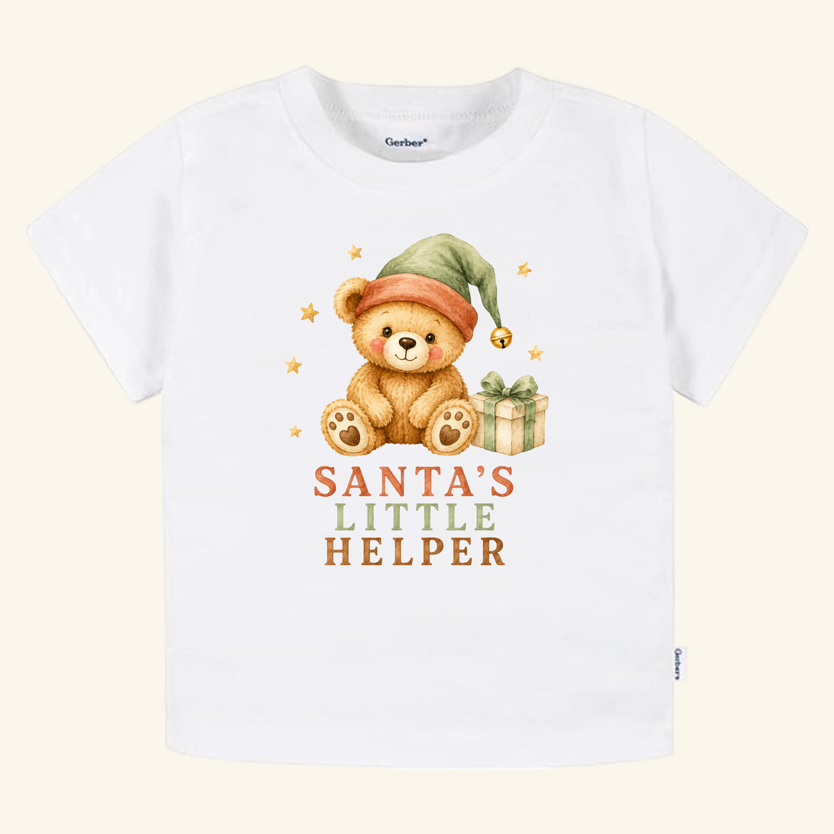 Santa’s Little Helper Toddler Shirt – Teddy Bear Christmas Tee featuring a white toddler t-shirt with a watercolor illustration of a teddy bear wearing a green elf hat next to a gift and the text Santa’s Little Helper underneath.