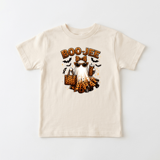 The Toodleroos Boo-Jee Ghost Toddler Girls Shirt – Leopard Print Halloween Tee features a cream base adorned with a stylish ghost sporting sunglasses, a leopard print headband, and holding a matching leopard print bag. The word “BOO-JEE” appears above the design, surrounded by playful bats and stars, making this trendy shirt the perfect Halloween outfit for little ones who want to stand out in style!.