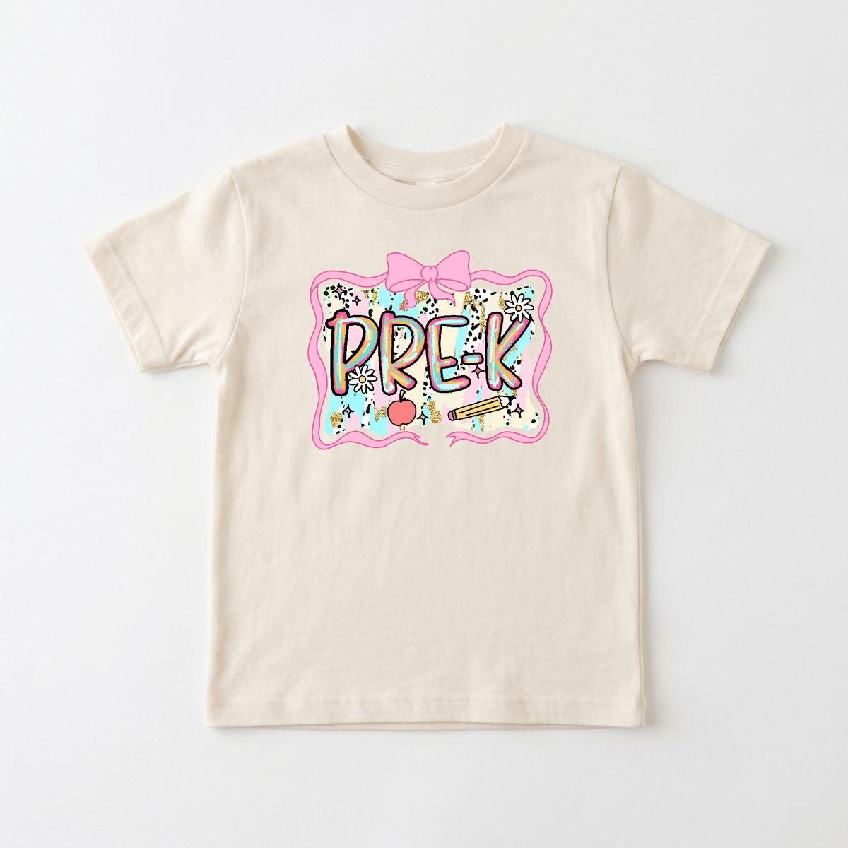 The Toodleroos Pre-K Youth Tee – Bow & Apple Back to School Shirt features a beige design with a vibrant PREK graphic framed in pink, adorned with flowers, a bow, hearts, and stars on the chest—making it the perfect cute Pre-K or first day of school shirt for your little one.