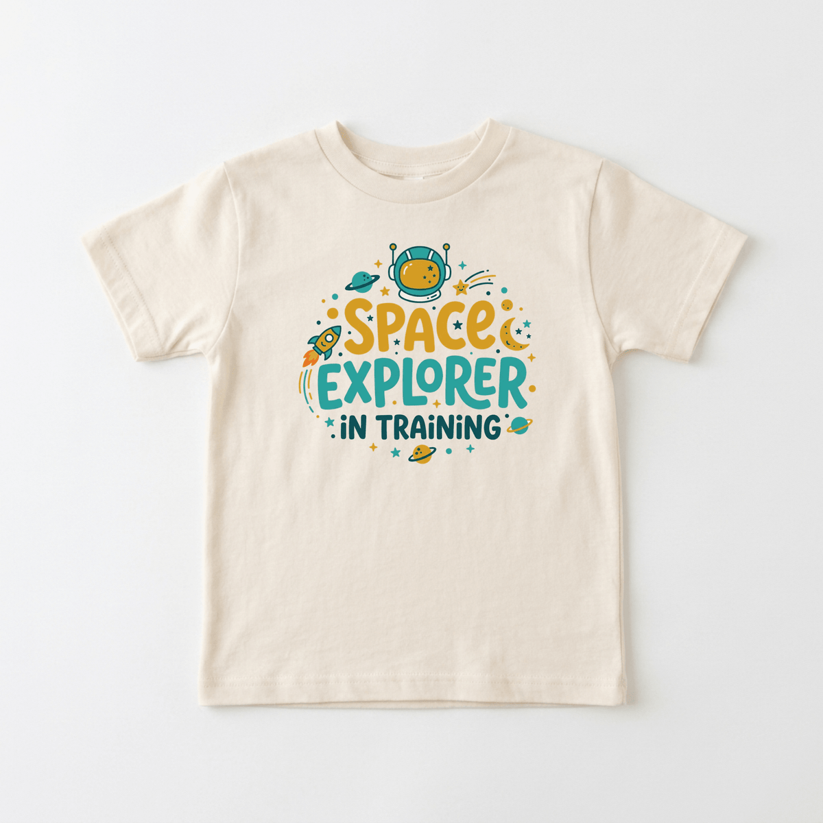 Dress your little adventurer in the Toodleroos Space Explorer in Training Toddler Shirt – Astronaut Tee. This cream-colored t-shirt features a vibrant design with an astronaut helmet, stars, rockets, and planets, along with playful “Space Explorer in Training” text on the front. An ideal space-themed toddler shirt for inspiring future astronauts!.