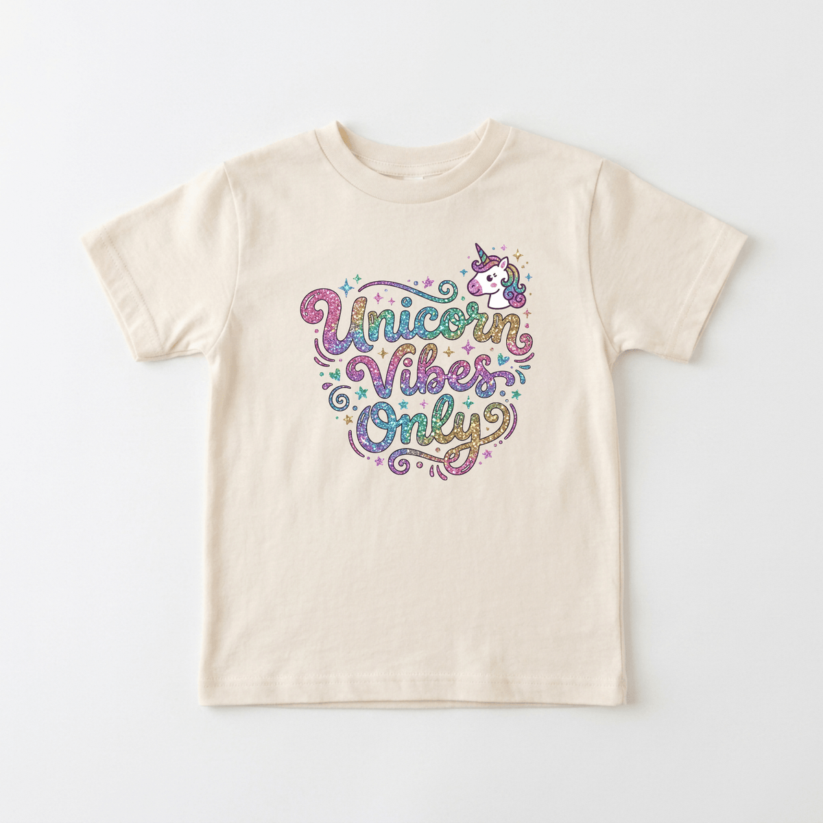 The Toodleroos Unicorn Vibes Only Toddler Girls Shirt – Sparkle Unicorn Tee is a cream-colored T-shirt featuring colorful, glittery text that says “Unicorn Vibes Only” with a small unicorn graphic above the words, making this playful rainbow glitter shirt perfect for unicorn-loving toddlers or as a fun girls’ birthday shirt.