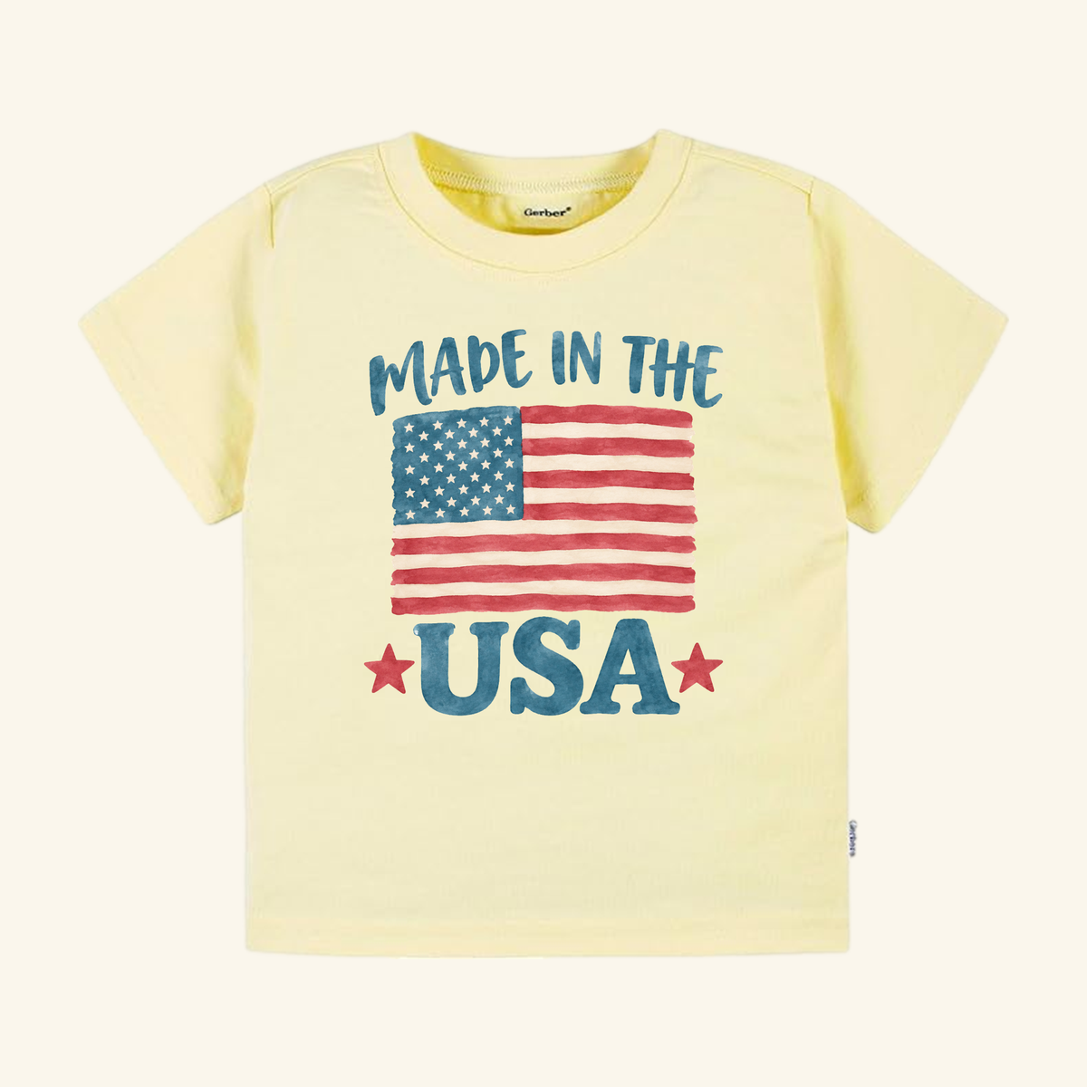 Pale yellow Made in the USA Toddler Shirt – Patriotic American Flag Tee featuring a watercolor American flag graphic and the text MADE IN THE USA with two red stars.