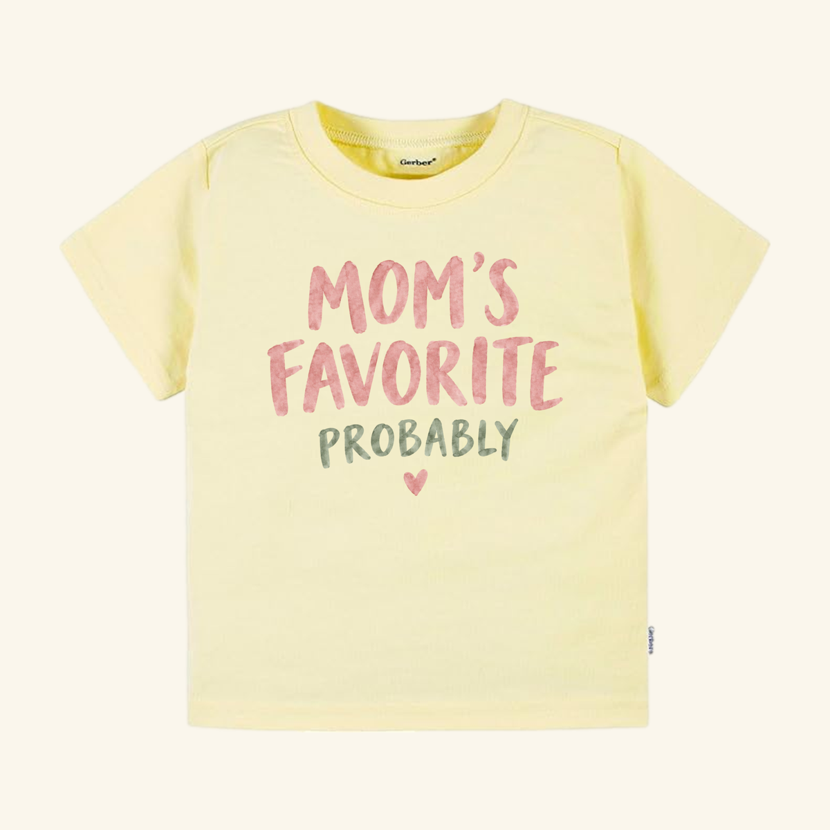 Pale yellow Mom’s Favorite Probably Toddler Shirt with the text MOMS FAVORITE PROBABLY in pink and green lettering, finished with a small heart.
