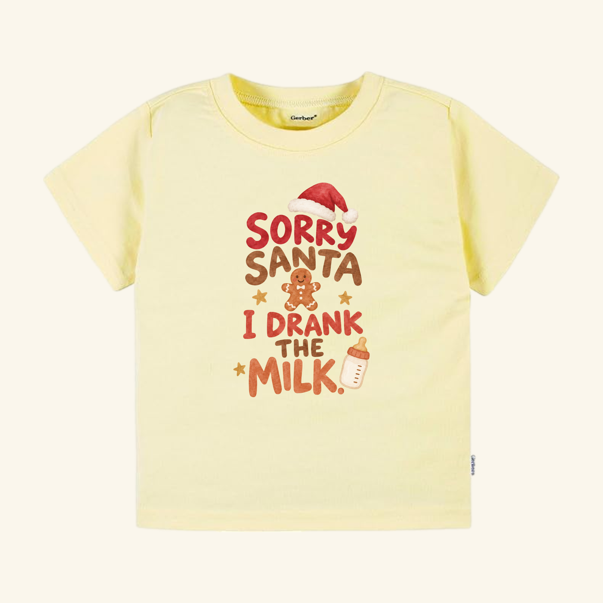 Pale yellow Sorry Santa I Drank the Milk Toddler Shirt – Funny Christmas Tee featuring a Santa hat, a gingerbread man, a baby bottle, and the text Sorry Santa I Drank the Milk.