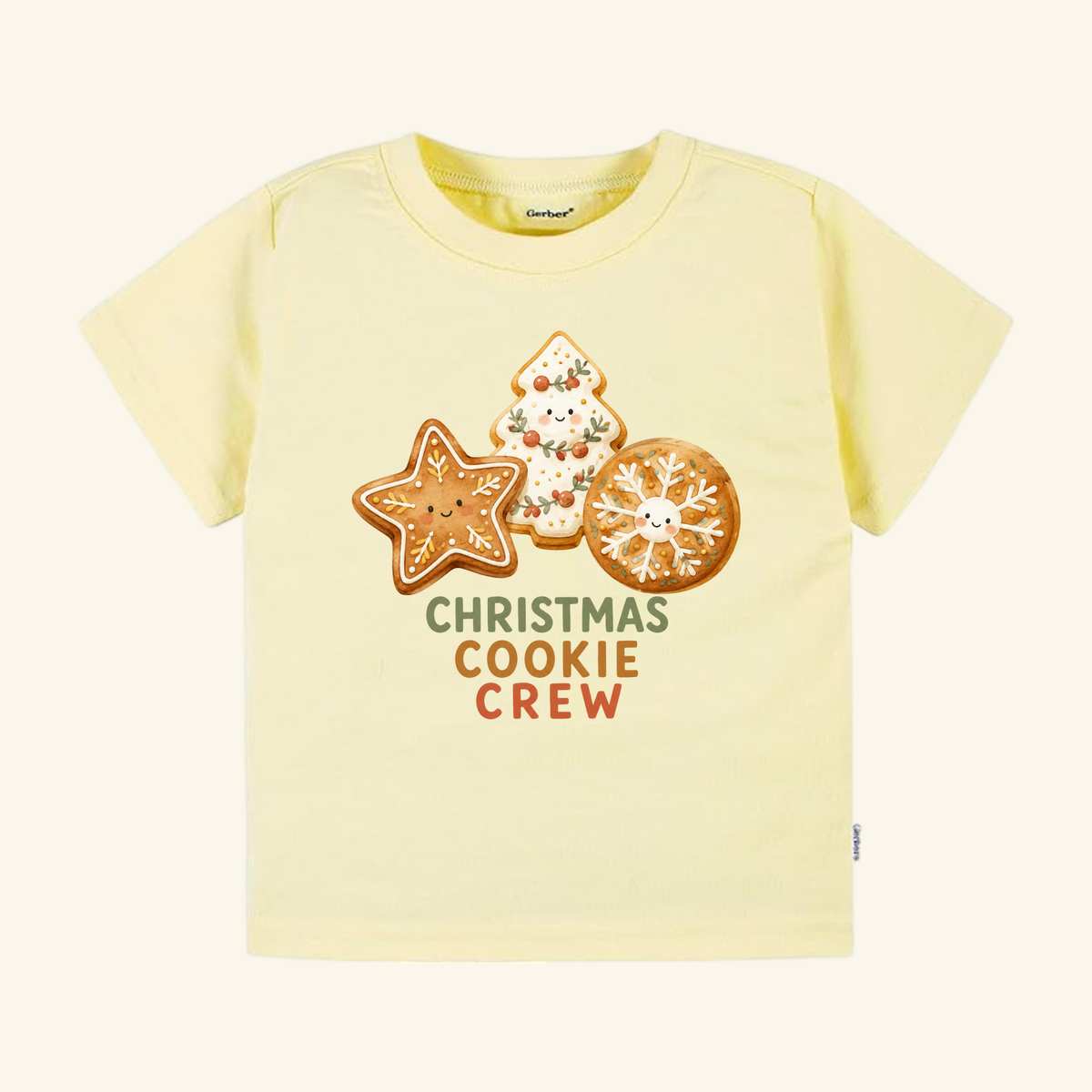 Pale yellow Christmas Cookie Crew Toddler Shirt featuring three smiling holiday cookies.