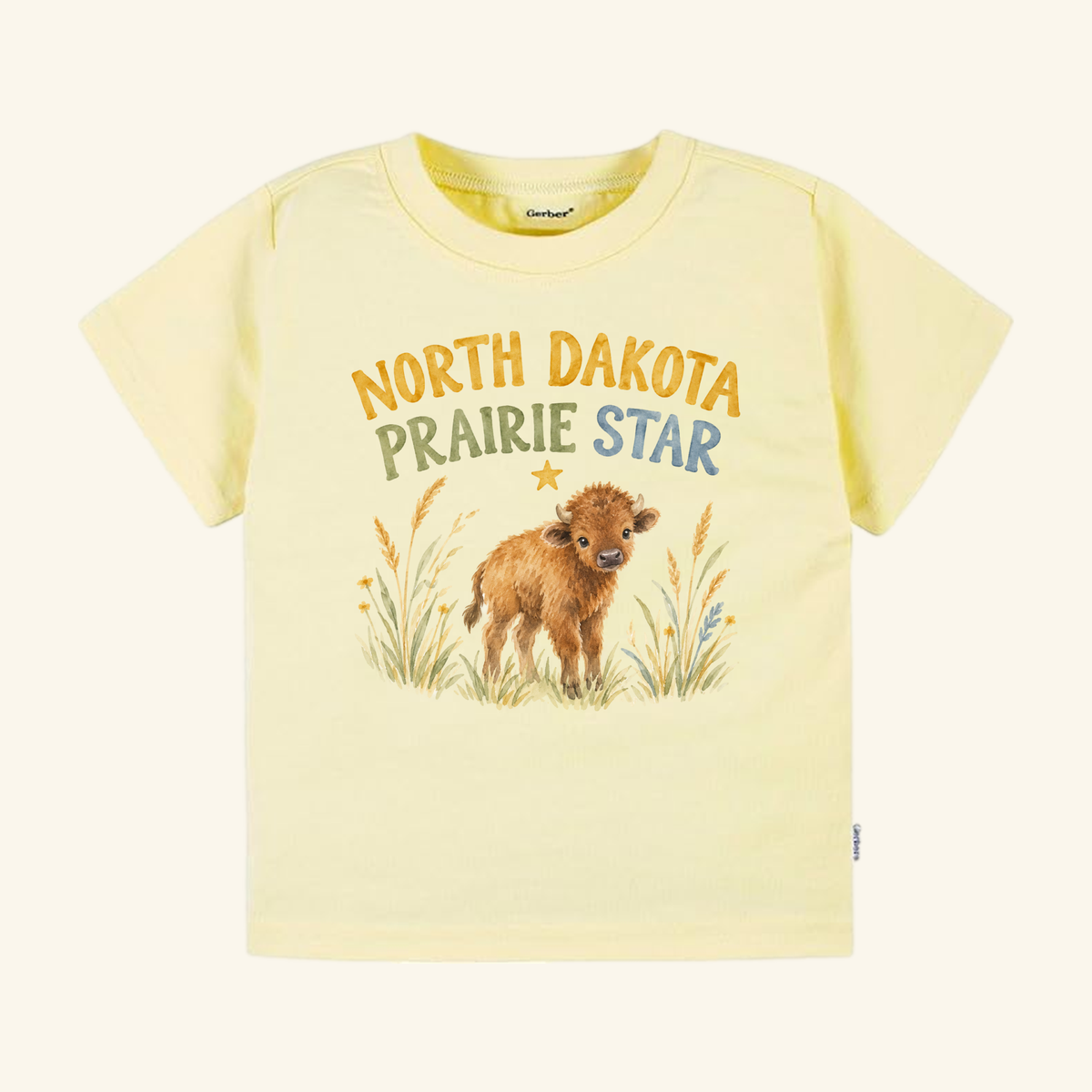 Pale yellow North Dakota Toddler Shirt – Prairie Star Baby Bison Tee featuring a graphic of a baby bison in prairie grass.