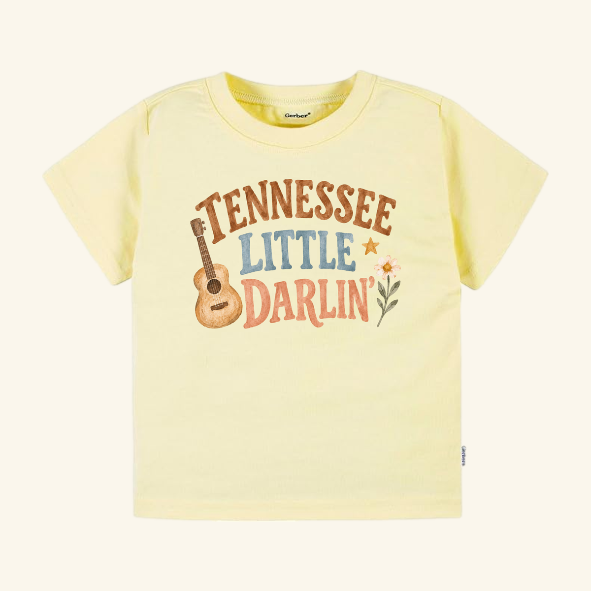 Pale yellow Toodleroos Tennessee Toddler Shirt – Little Darlin’ Guitar Country Tee featuring a guitar graphic and the text Tennessee Little Darlin.