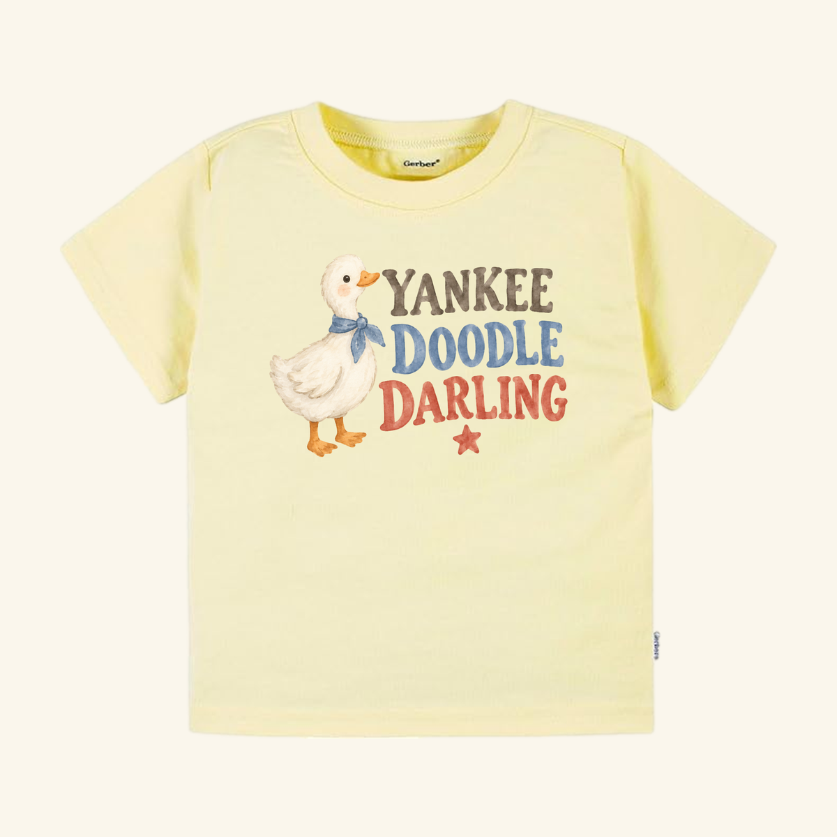 Pale yellow Yankee Doodle Darling Toddler Shirt – Patriotic Duckling Tee featuring a duckling wearing a blue neckerchief, the text YANKEE DOODLE DARLING, and a small red star.