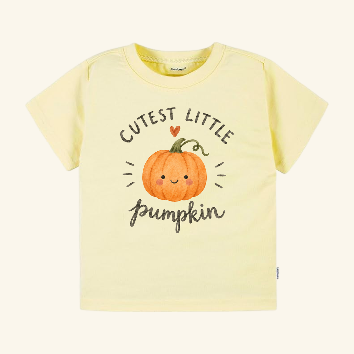 Pale yellow Cutest Little Pumpkin Toddler Shirt featuring a graphic of a smiling orange pumpkin with a small heart above and the text CUTEST LITTLE PUMPKIN.