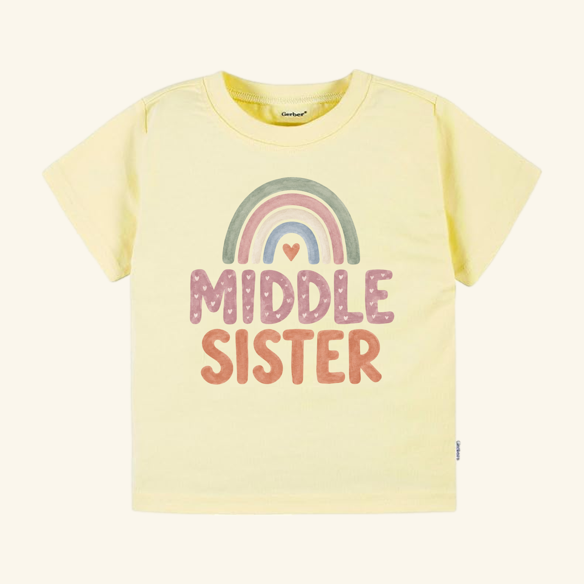 Light yellow Middle Sister Toddler Shirt – Boho Rainbow Sibling Tee featuring a boho rainbow graphic above the text MIDDLE SISTER with small heart accents.