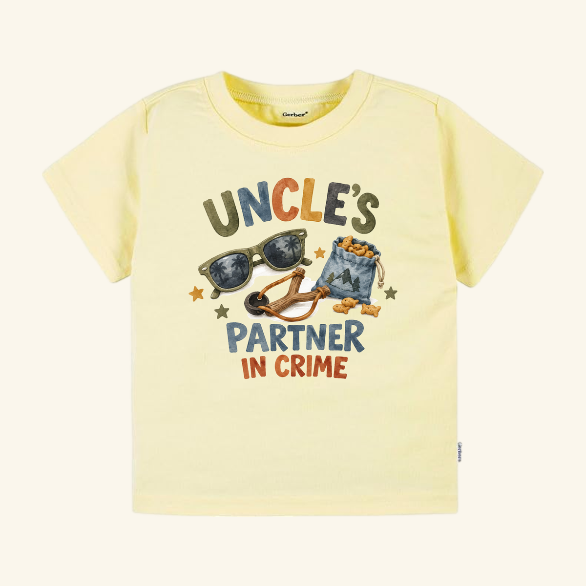 Pale yellow Funny Uncle Toddler Shirt – Uncle’s Partner in Crime Tee featuring a graphic of sunglasses, a slingshot, and a bag of crackers with the text Uncle’s Partner in Crime.