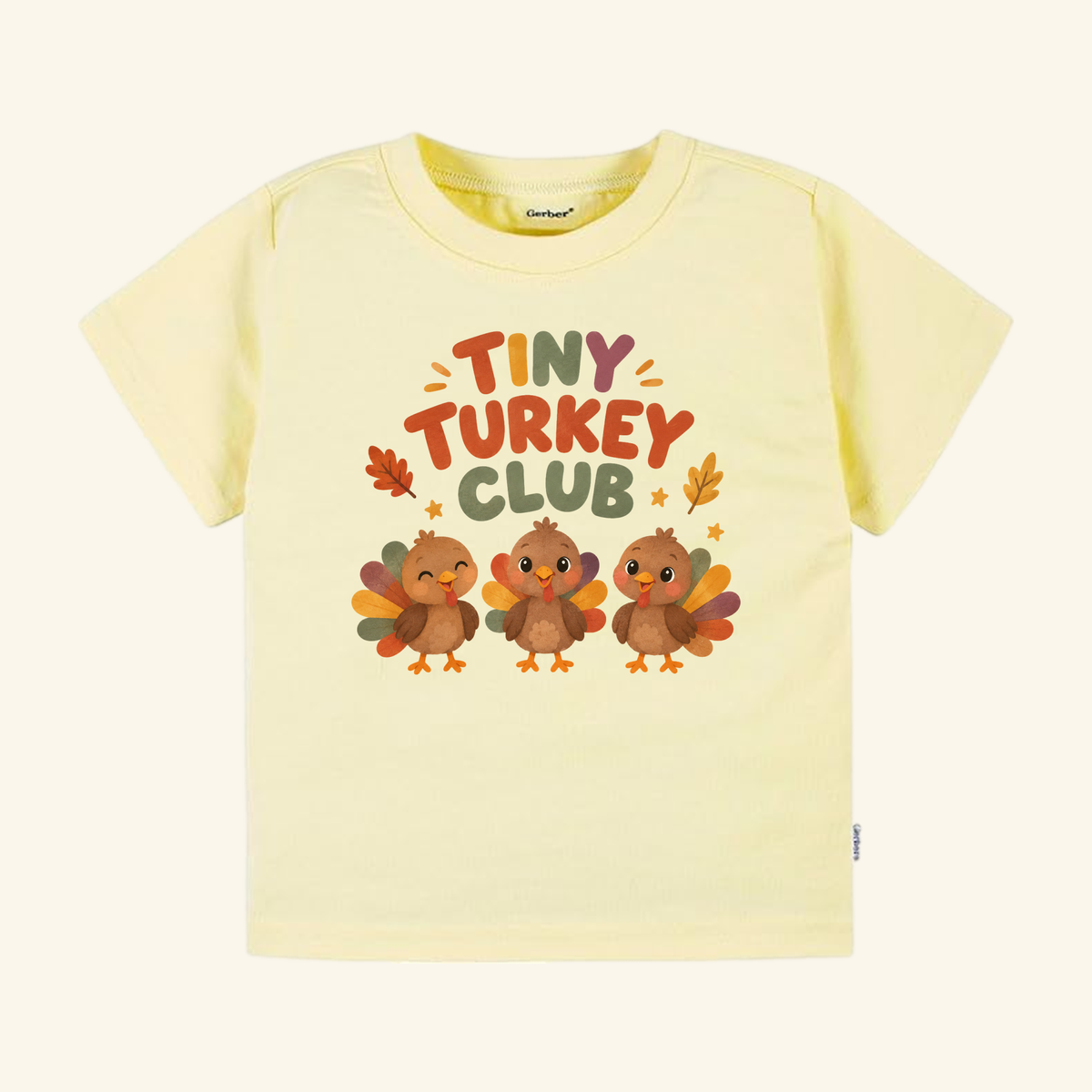 Pale yellow short-sleeve Tiny Turkey Club Toddler Thanksgiving Shirt featuring three cartoon turkeys and the colorful text Tiny Turkey Club.