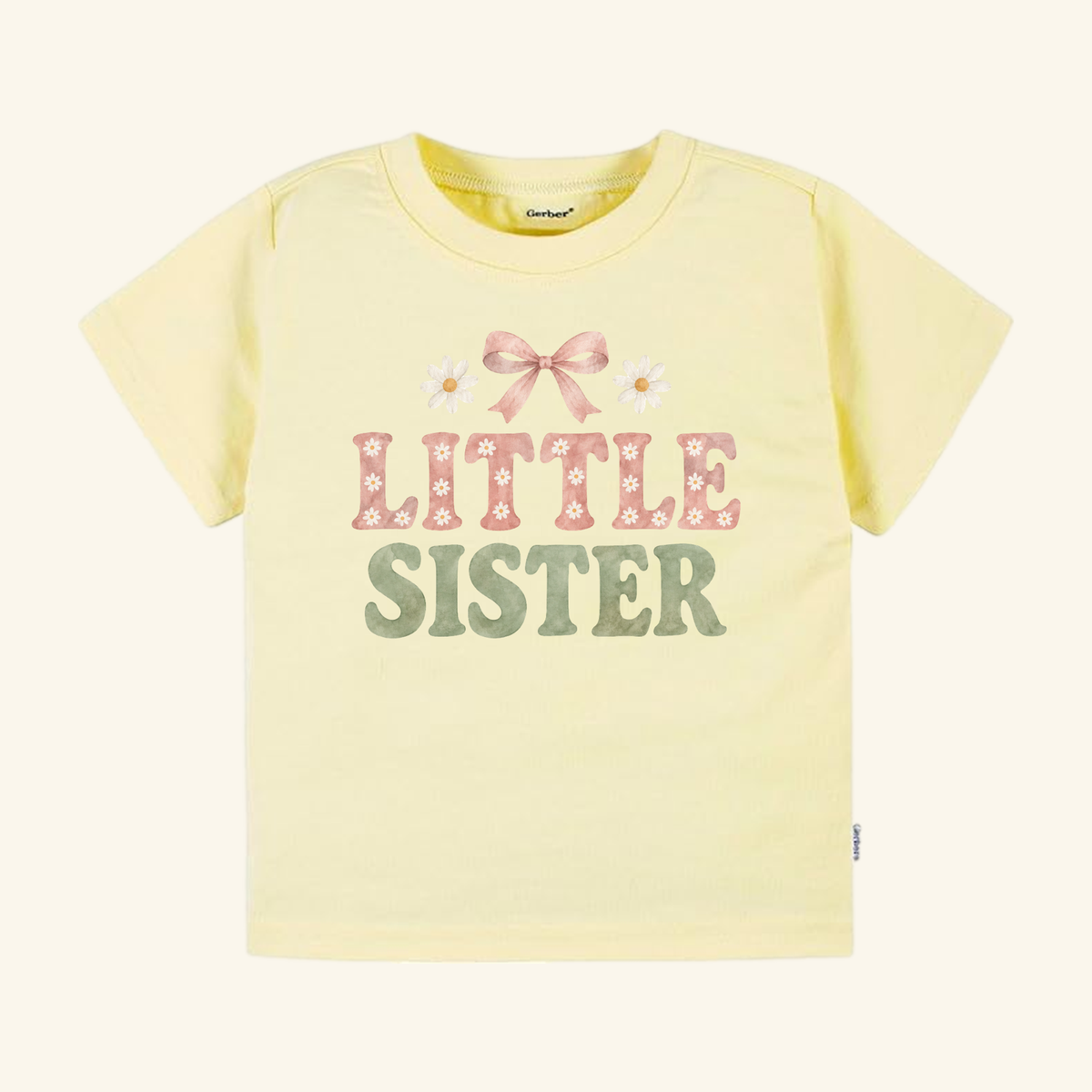 Pale yellow Little Sister Toddler Shirt – Daisy Bow Sibling Tee featuring a pink bow and two daisies above the text LITTLE SISTER in pink and green letters.