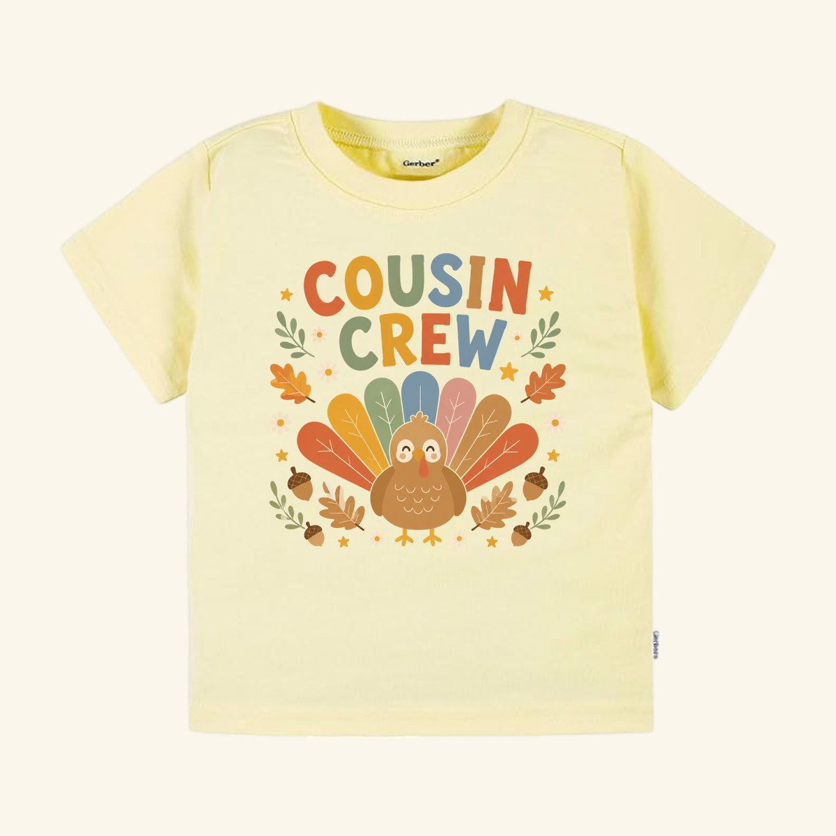 Toodleroos Thanksgiving Cousin Shirt – Cousin Crew Turkey Toddler Tee in pale yellow, featuring a graphic of a cartoon turkey with autumn leaves, acorns, and stars.
