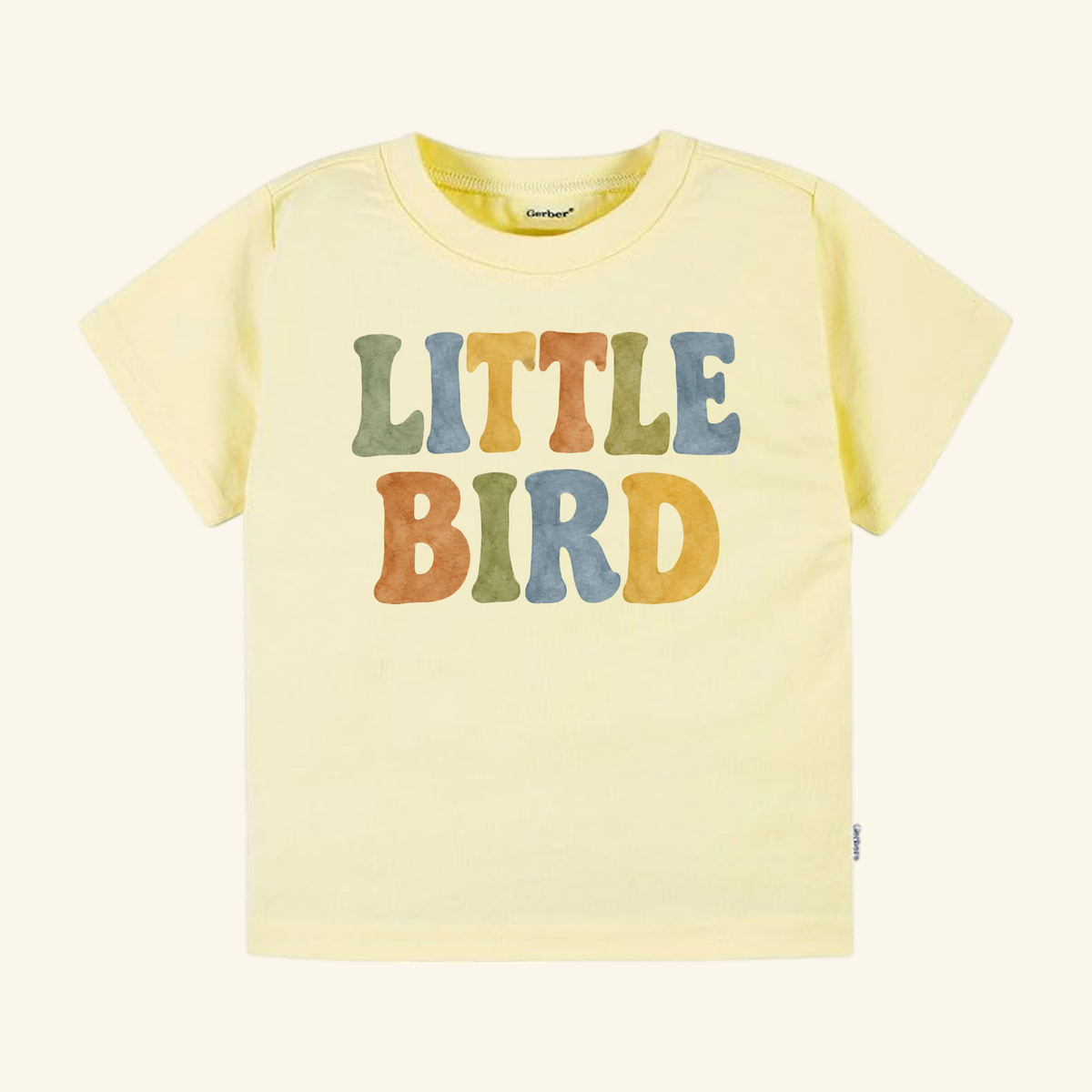 Little Bird Toddler Shirt – Retro Watercolor Lettering Tee in light yellow with LITTLE BIRD printed in multicolored, vintage-style lettering.
