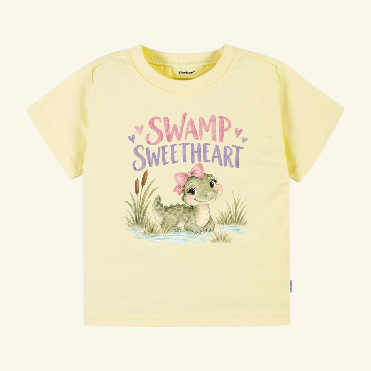 Light yellow short-sleeve Swamp Sweetheart Toddler Shirt – Baby Alligator Girls Tee featuring an illustration of a baby gator with a pink bow and the text SWAMP SWEETHEART in pink and purple.