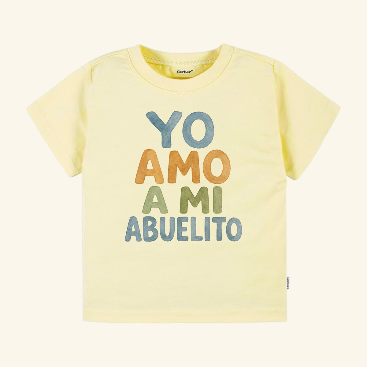 Pale yellow Yo Amo A Mi Abuelito Toddler Shirt featuring the print on the front in stacked, multi-colored letters.