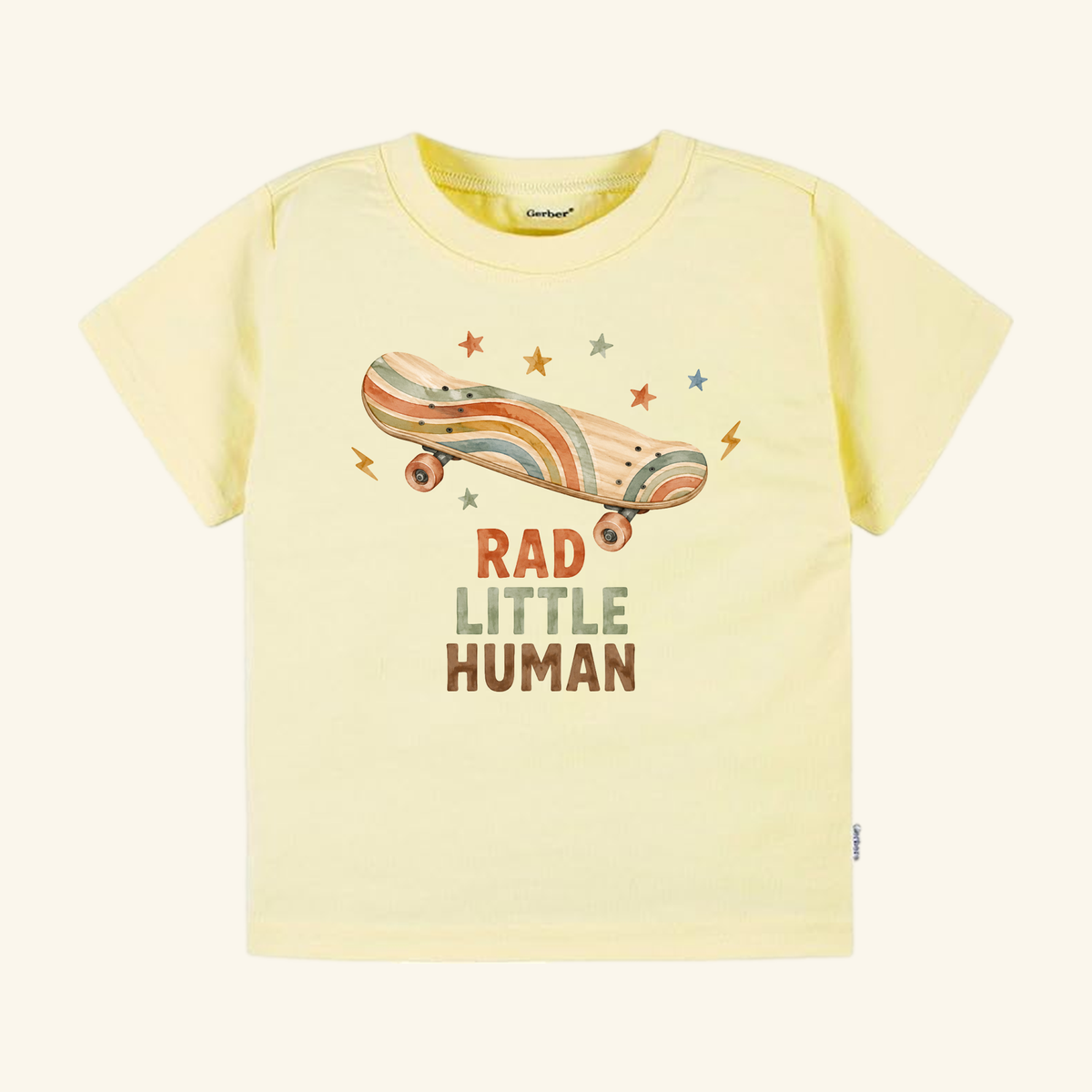 Light yellow Toodleroos Skateboard Toddler Shirt – Rad Little Human Retro Tee featuring a retro skateboard surrounded by small stars and lightning bolts, with the text RAD LITTLE HUMAN printed below.
