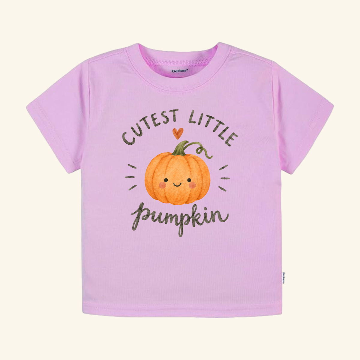 Light pink Toodleroos Cutest Little Pumpkin Toddler Shirt with a graphic of a smiling orange pumpkin and the text Cutest Little Pumpkin above and below it.