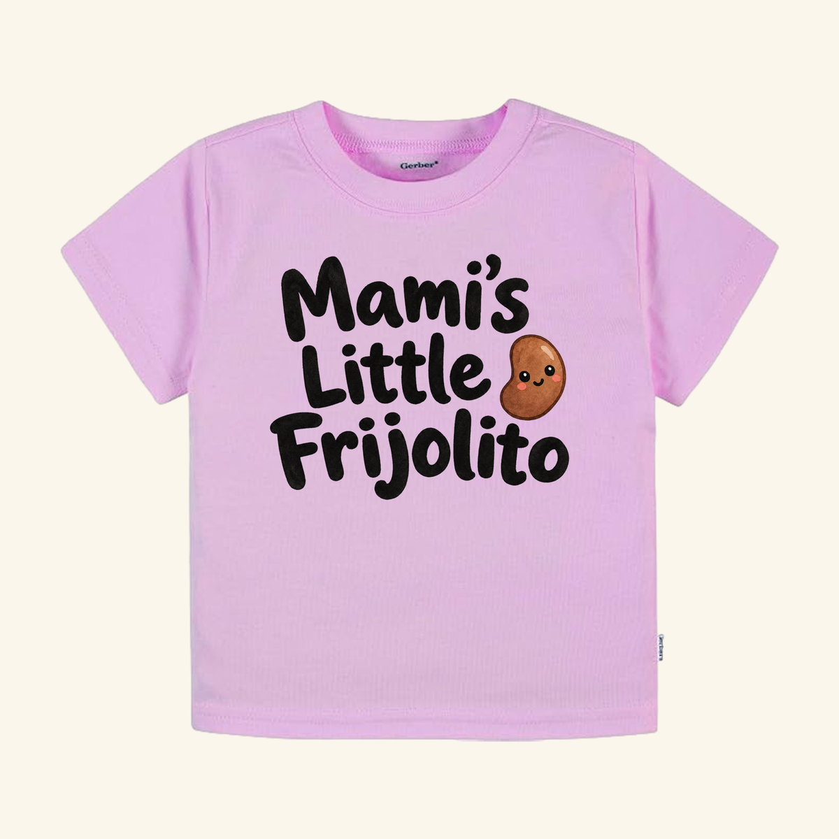 Light pink Mami’s Little Frijolito Toddler Shirt featuring the text and a small cartoon bean with a face.
