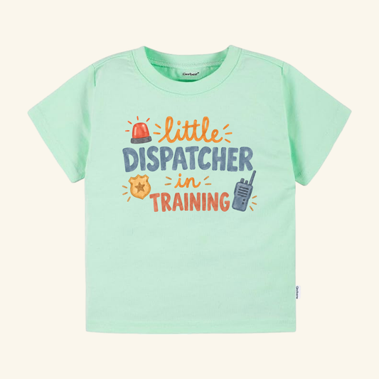 Light green Toodleroos Little Dispatcher in Training Toddler Shirt featuring little DISPATCHER in TRAINING text surrounded by a red siren, gold badge, and walkie-talkie.