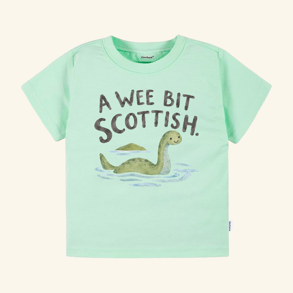 Light green A Wee Bit Scottish Toddler Shirt featuring an illustration of the Loch Ness monster and the text A WEE BIT SCOTTISH.