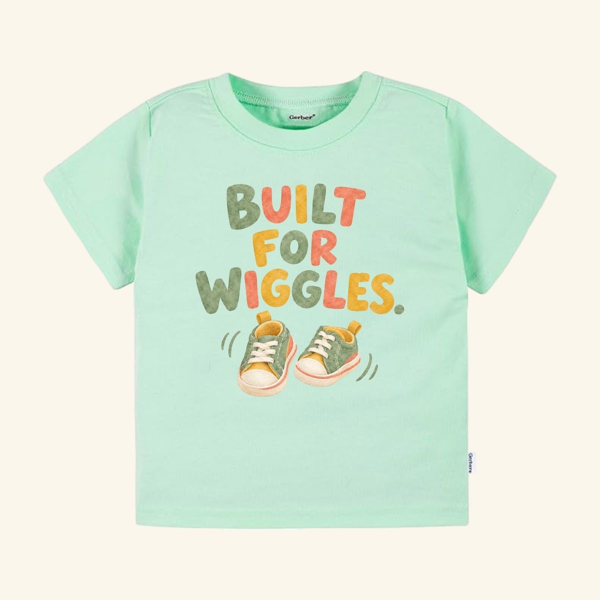 Mint green Built for Wiggles Toddler Shirt featuring the text BUILT FOR WIGGLES and an illustration of two small sneakers with motion lines.