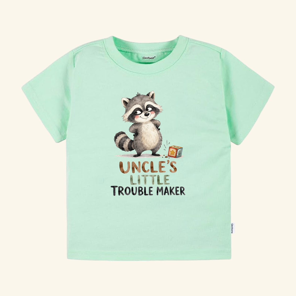Light green Toodleroos Funny Uncle Toddler Shirt – Uncle’s Little Troublemaker Tee featuring an illustration of a mischievous raccoon and the text Uncle’s Little Troublemaker.
