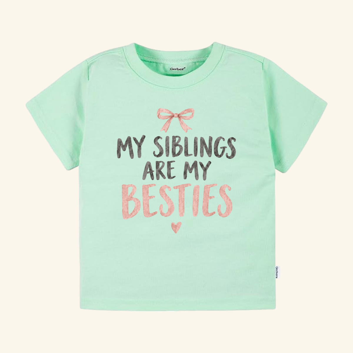 Light green My Siblings Are My Besties Toddler Shirt – Pink Bow Sibling Tee featuring a pink bow, a small heart, and the text MY SIBLINGS ARE MY BESTIES.