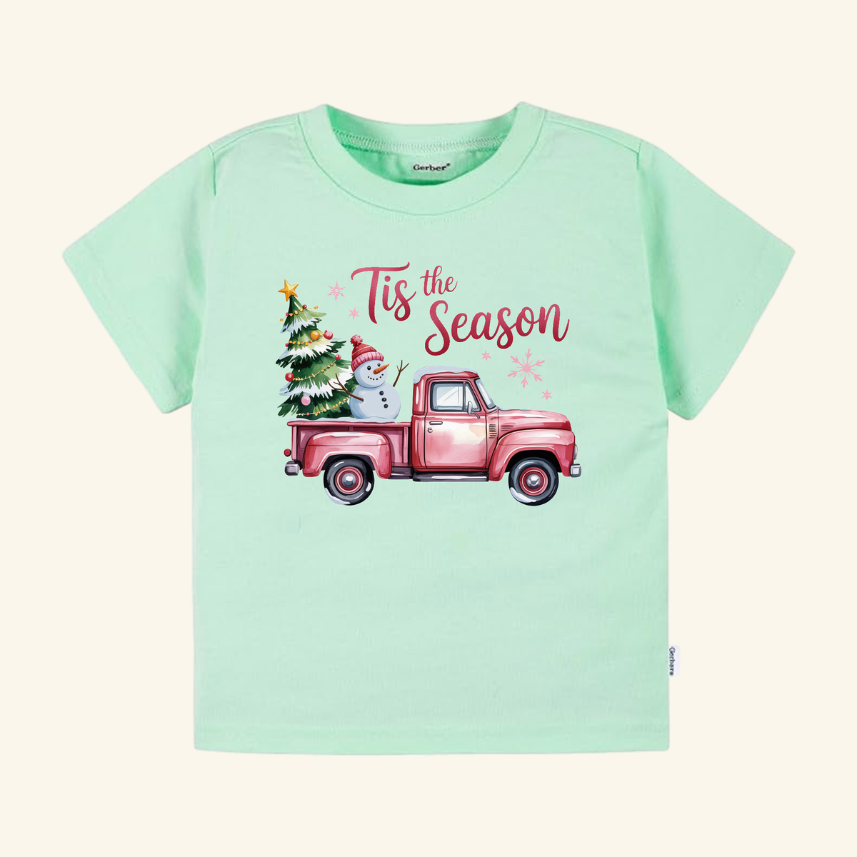 Mint green Pink Christmas Truck Toddler Shirt – ’Tis the Season Snowman Tee featuring a pink vintage pickup truck carrying a snowman and a decorated tree, with Tis the Season printed above.