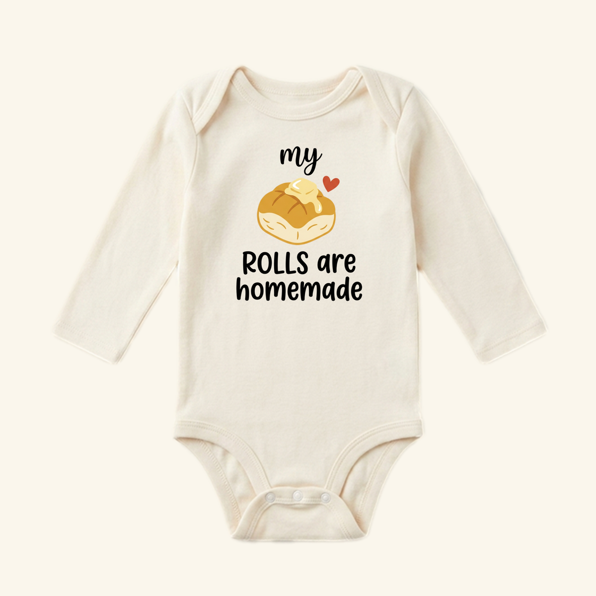 Toodleroos My Rolls Are Homemade Baby Thanksgiving Onesie - Fall Bodysuit in cream, featuring long sleeves and an illustration of a buttered dinner roll with the text my ROLLS are homemade.