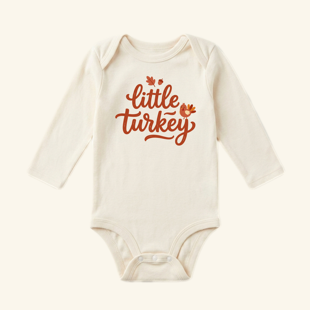 Off-white long-sleeve Little Turkey Baby Onesie with a small cartoon turkey, leaf, and acorn printed on the chest.