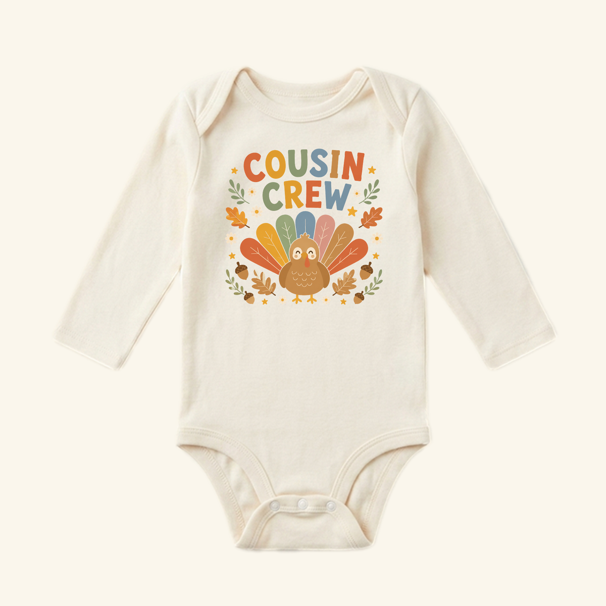 Cream-colored Thanksgiving Baby Onesie – Cousin Crew Turkey Bodysuit featuring a turkey graphic, colorful autumn leaves, and acorns.