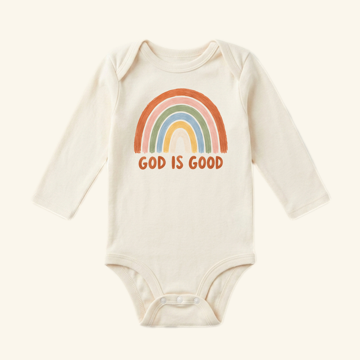 The Christian Baby Onesie – God Is Good Rainbow Bodysuit by Toodleroos features a pastel rainbow and GOD IS GOOD on cream fabric—perfect as a sweet Christian baby gift.