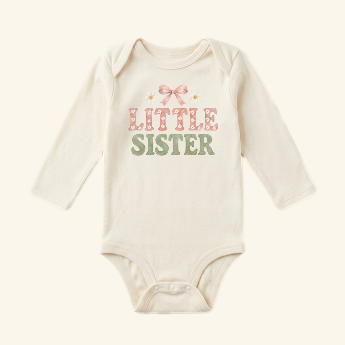 Toodleroos Little Sister Baby Onesie – Daisy Bow Sibling Bodysuit in cream with long sleeves, a pink bow, small daisies, and the words LITTLE SISTER in pink and green lettering.