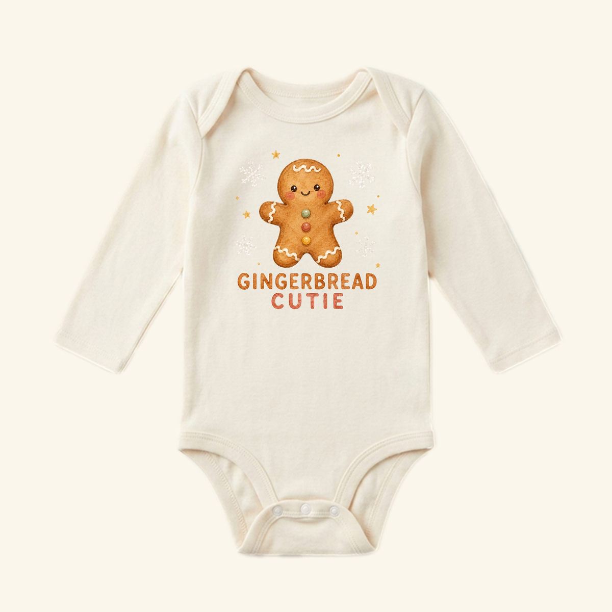 Long-sleeved cream Gingerbread Cutie Baby Onesie featuring a gingerbread man illustration and the text GINGERBREAD CUTIE printed on the chest.