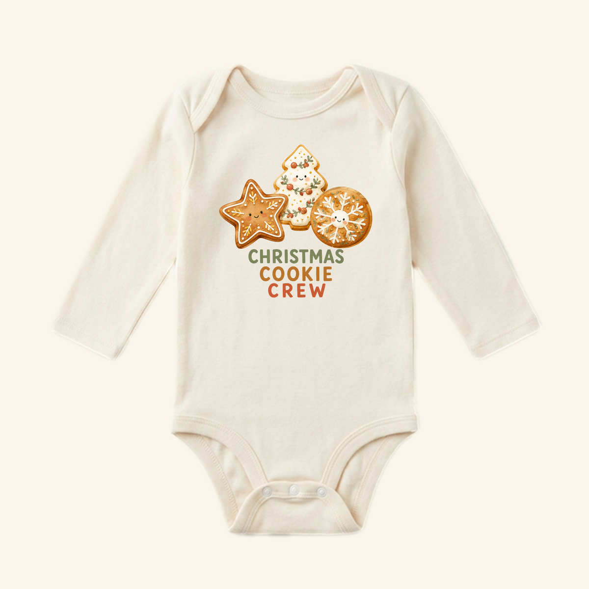 Cream-colored long-sleeve Christmas Cookie Crew Baby Onesie featuring a graphic of three smiling decorated sugar cookies and the text CHRISTMAS COOKIE CREW.