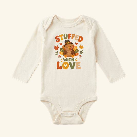 Stuffed With Love Baby Onesie – Thanksgiving Turkey Bodysuit featuring a turkey in a pilgrim hat surrounded by autumn leaves and the text Stuffed with Love.