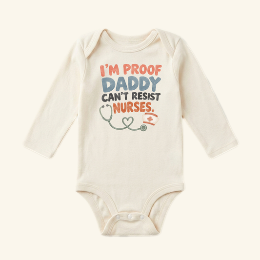 Cream-colored long-sleeve I’m Proof Daddy Can’t Resist Nurses Baby Onesie – Funny Nurse Mom Bodysuit featuring a stethoscope, nurse’s cap, and the text I’m proof daddy can’t resist nurses.