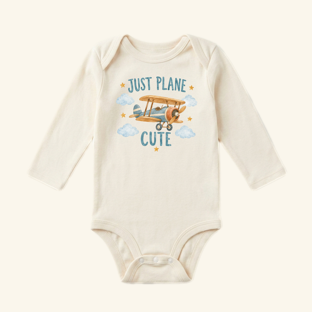 Just Plane Cute Baby Onesie – Funny Vintage Airplane Pun Bodysuit featuring a long-sleeved vintage airplane design with a graphic of a plane among clouds and stars and the text JUST PLANE CUTE.