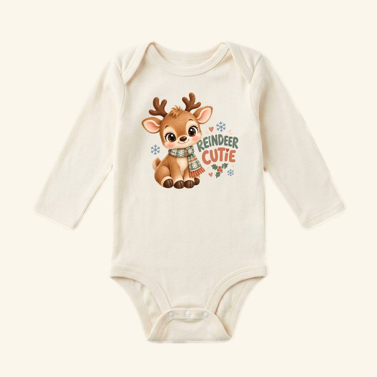 Cream-colored long-sleeve Reindeer Cutie Baby Onesie featuring a cartoon reindeer in a scarf, the text REINDEER CUTIE, and holiday accents.