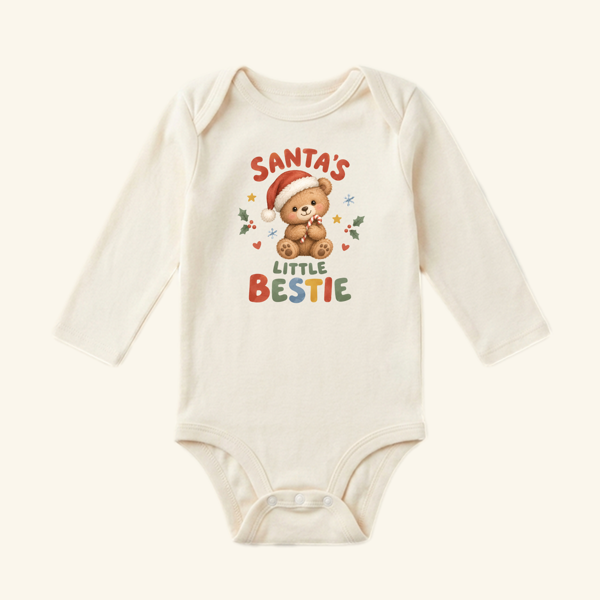 Santa’s Little Bestie Baby Onesie – Teddy Bear Christmas Bodysuit in cream with a long-sleeved design featuring a teddy bear in a Santa hat holding a candy cane, surrounded by the text Santa’s Little Bestie and small seasonal icons.