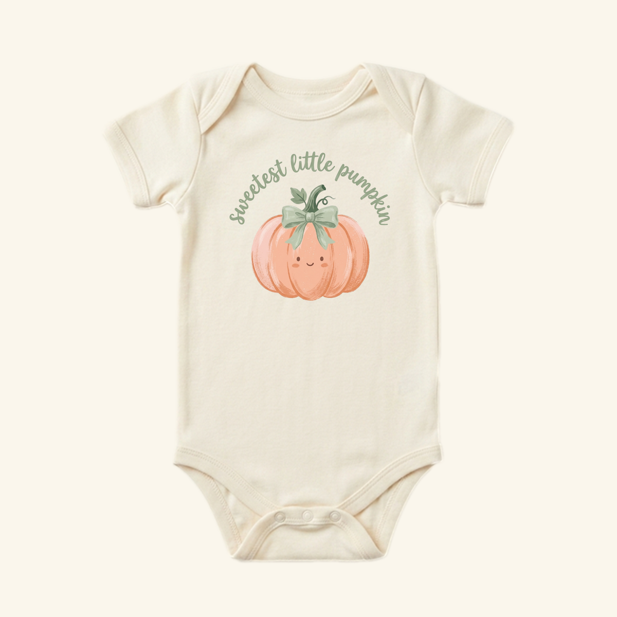 Cream-colored Toodleroos Sweetest Little Pumpkin Baby Onesie featuring a cartoon peach pumpkin with a green bow and the text sweetest little pumpkin printed on the chest.